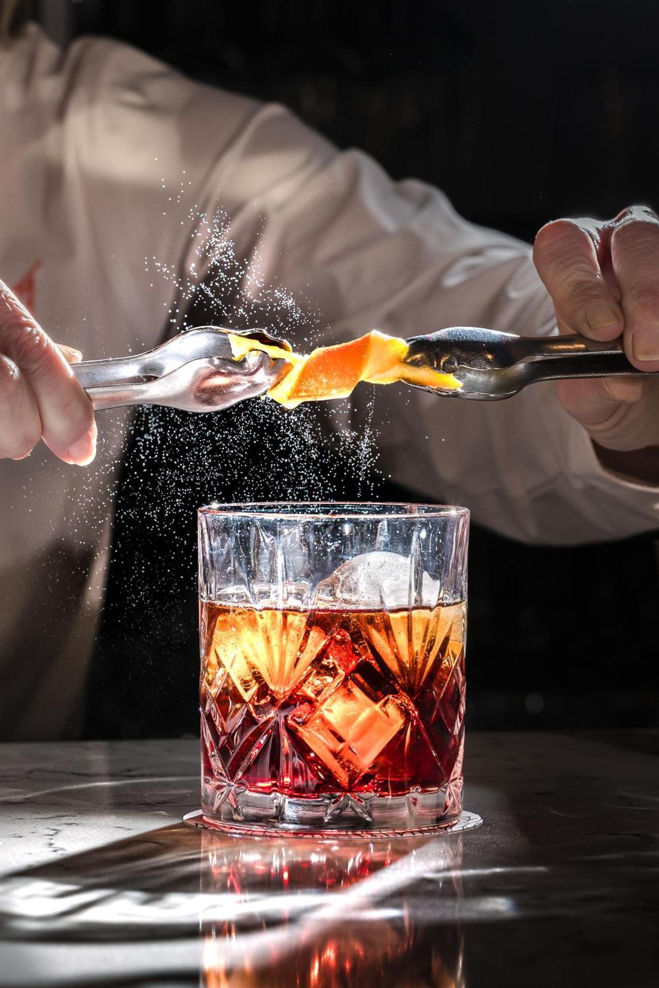 Hospes Palacio De Arenales & Spa Caces Zewnętrze zdjęcie A bartender adding a lemon twist to a cocktail
